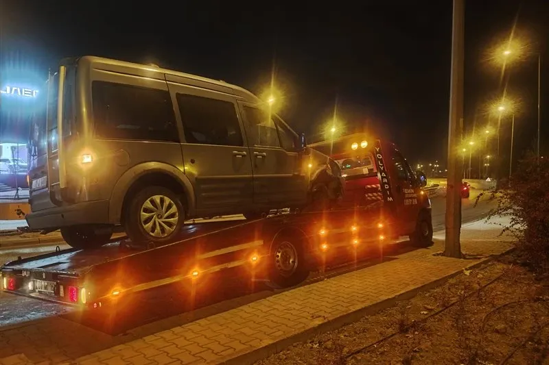 Gece sokak lambaları altında yol kenarında gri hafif ticari aracı taşıyan Emin Oto Kurtarma çekicisi