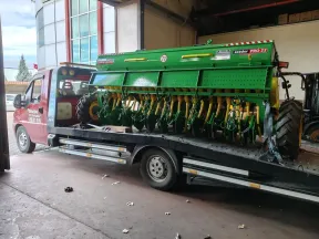 Depo girişinde yeşil tohum ekim makinesini (mibzer) kasasına sabitlemiş Emin Oto Kurtarma çekicisi